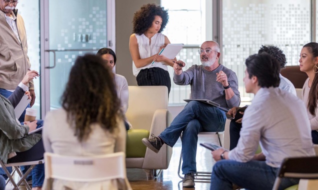 A group of people discuss in a circle