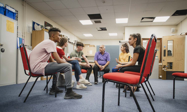 Teenagers sit in a circle and have a discussion