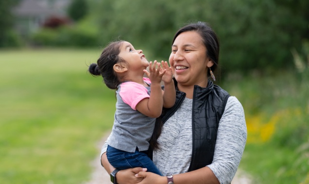 Native American mother holding her toddler-age daughter.