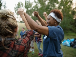 Photo of people outside with their hands raised