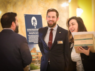 Decorative: Three people talking outside of an event hall