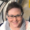 Photo of Lindsay Garber, young white woman with glasses and dark brown hair wearing a gray scarf.