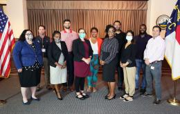 Diverse group of adults posing for a group photo in a small auditorium