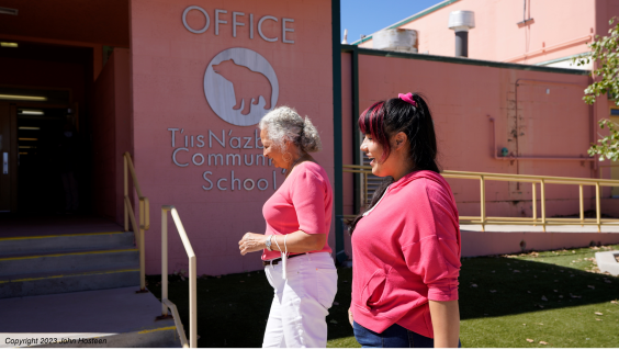 Two Native American women walking into a community school