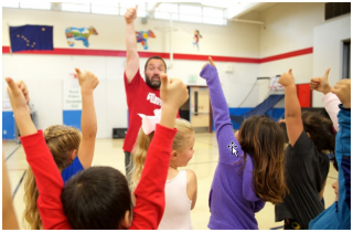 Image of coach and children in a gymnasium