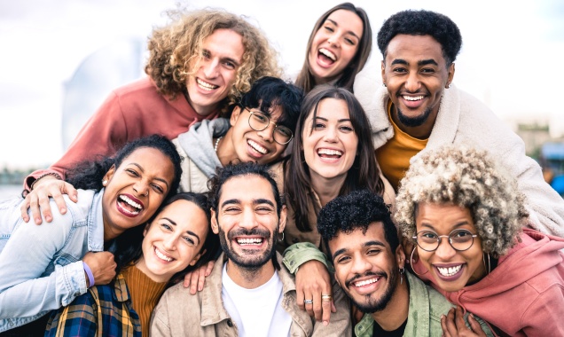 Stock photo of a group of people diverse in age, race, and gender smiling for a photo